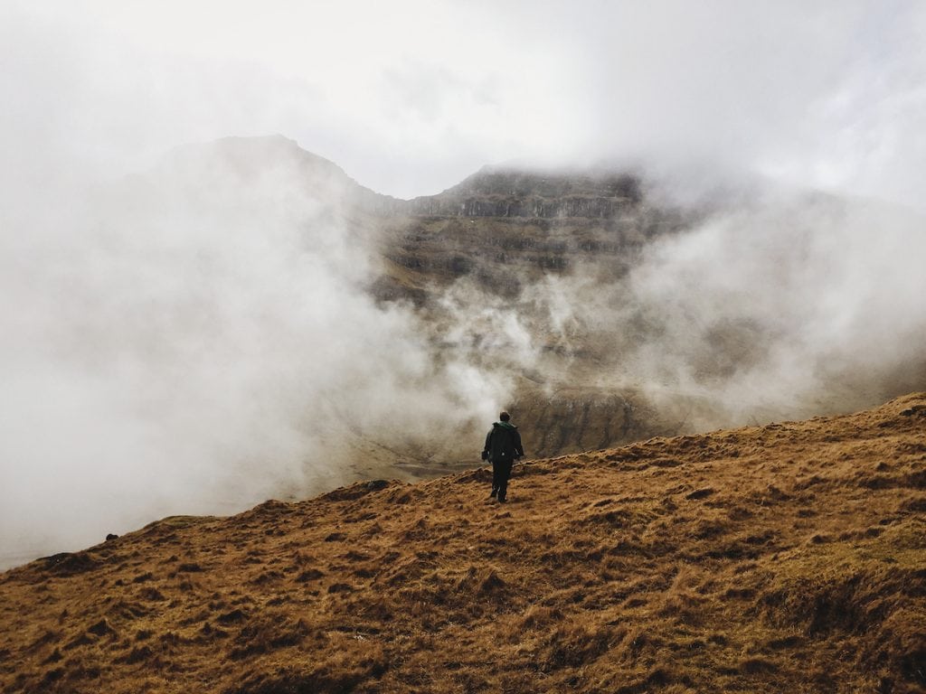 walking through the fog on kalsoy in trøllanes to get to the lighthouse in the faroe islands