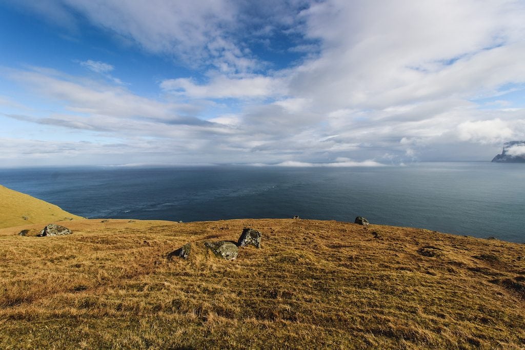 hiking through blue skies in the faroe islands in trøllanes to the kallur lighthouse on kalsoy island