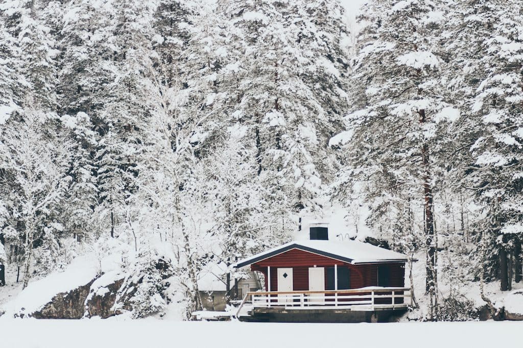 Nuuksio National Park: The Most Beautiful Winter Day Trip From Helsinki red house on frozen lake in forest