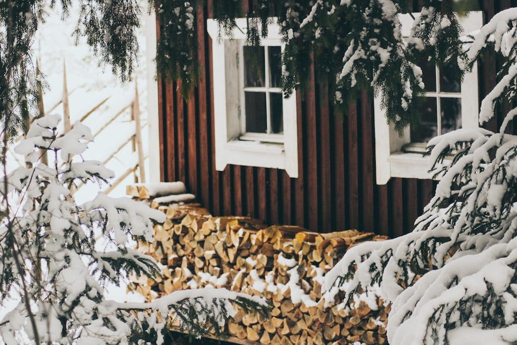 Nuuksio National Park: The Most Beautiful Winter Day Trip From Helsinki red house in forest with firewood