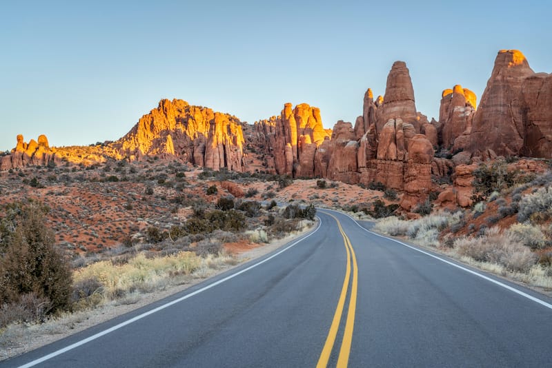 Winter sunrise driving on a highway through Arches National Park