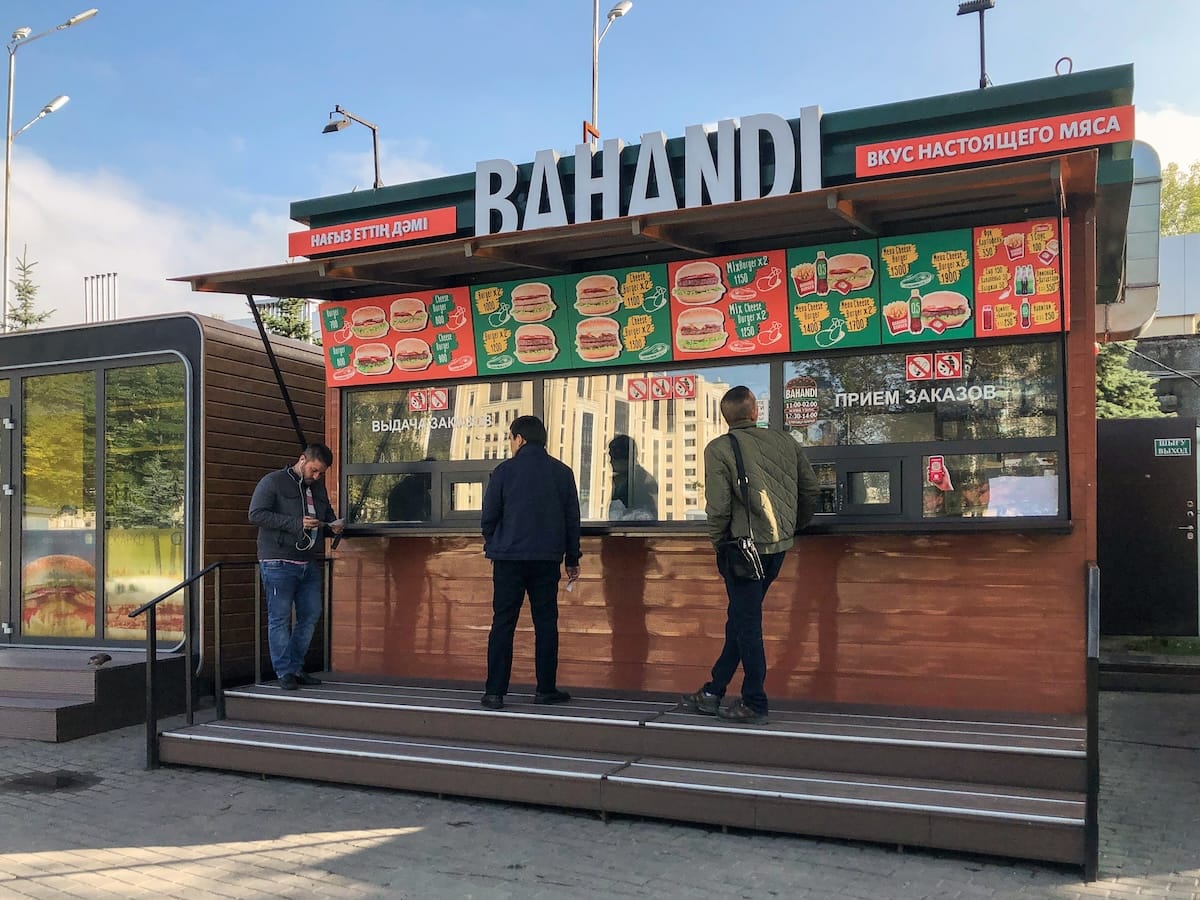 a burger kiosk with a few men outside it about to order
best restaurants in almaty, kazakhstan