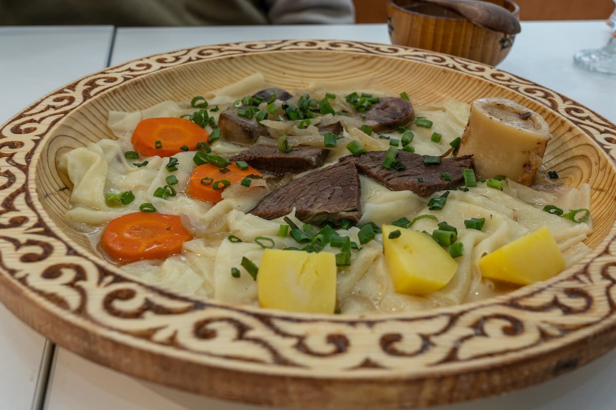 a plate of horsemeat, potatoes, carrots, and noodles in a bowl on a table
best restaurants in almaty, kazakhstan