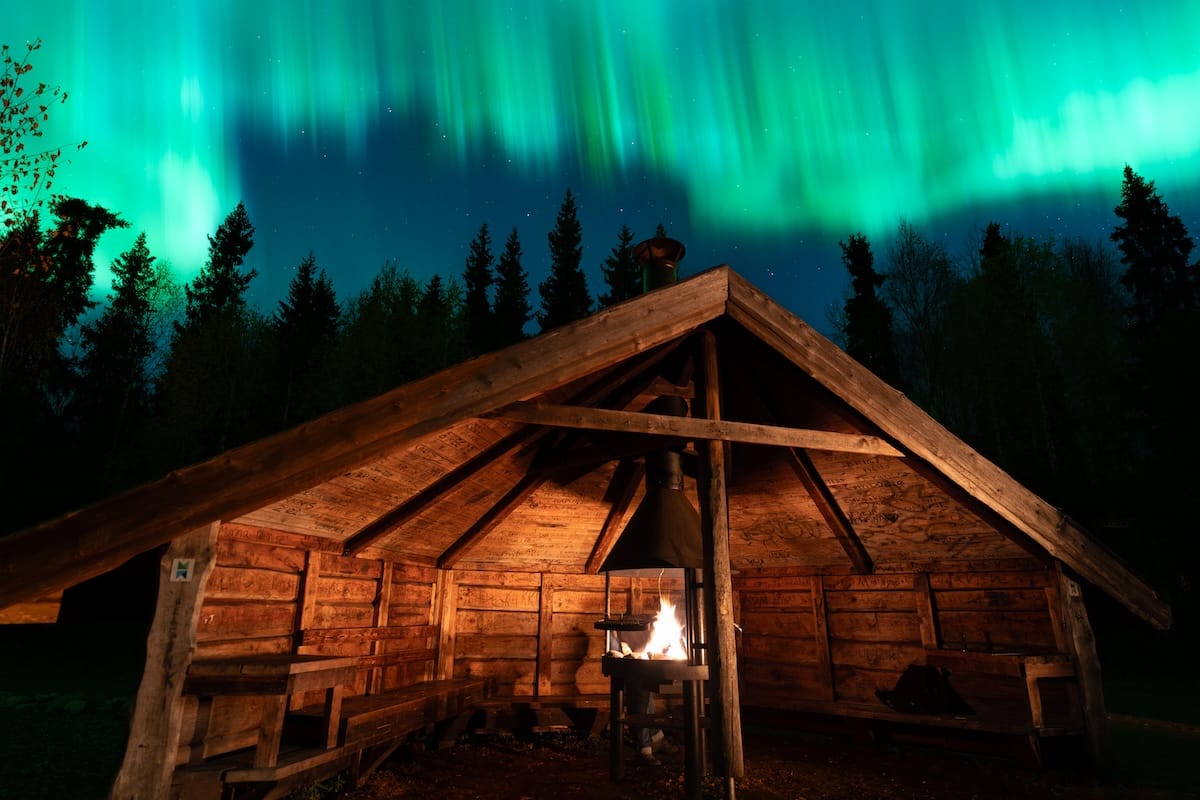 Northern lights over a fireplace in lapland