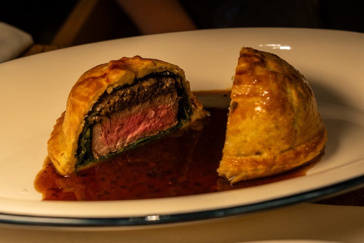 a beef wellington on top of a sauce on a plate
best restaurants in almaty, kazakhstan