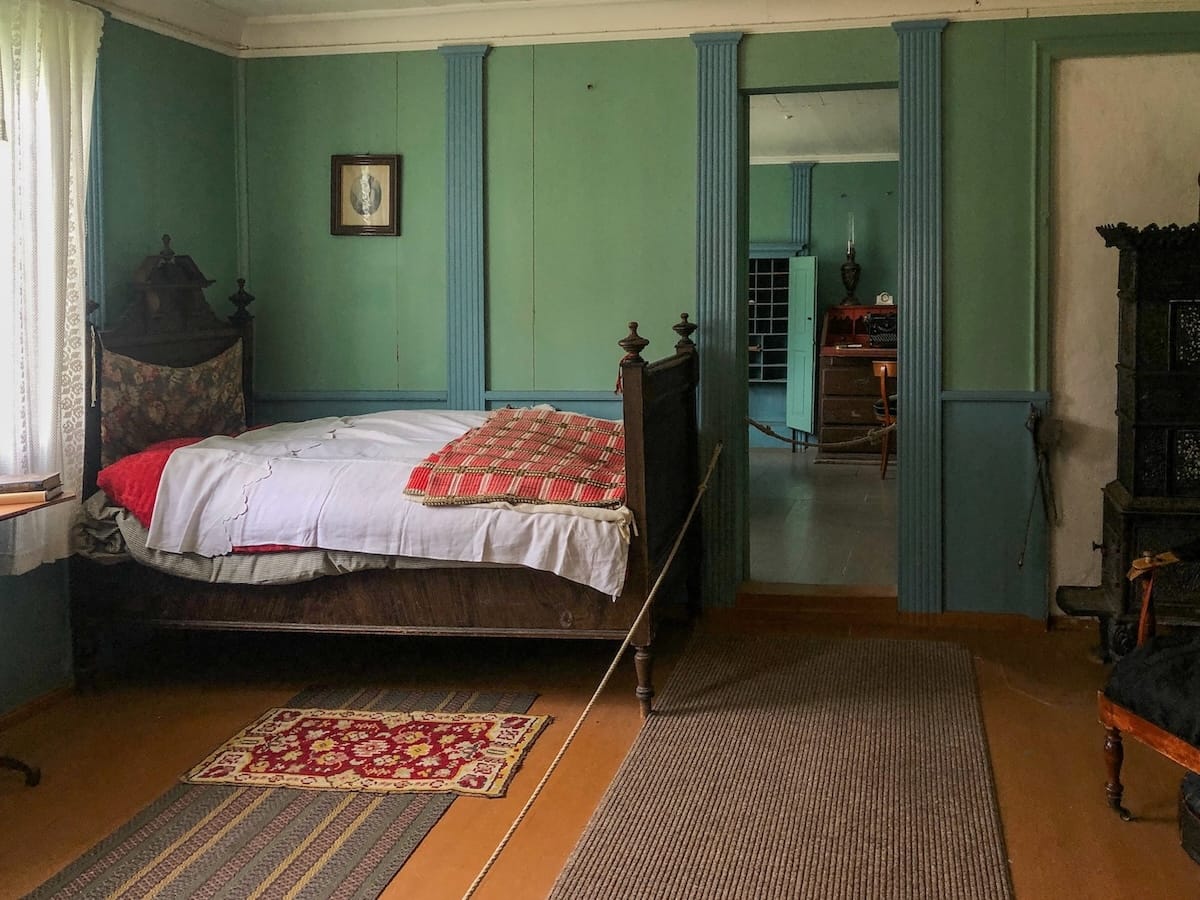 A bed inside a green room in a historic trading post