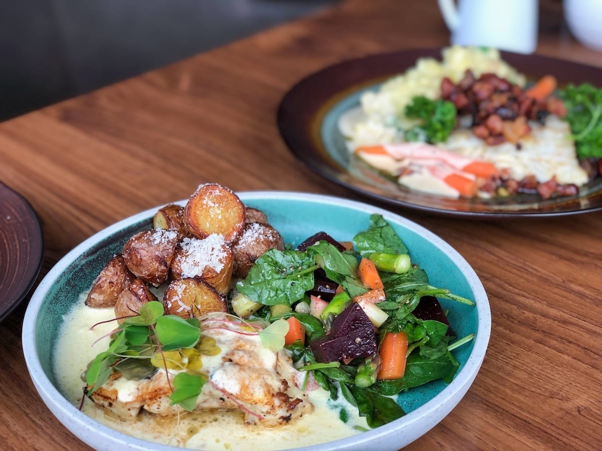 This is a plate of food with salad, monkfish, and potatoes on it