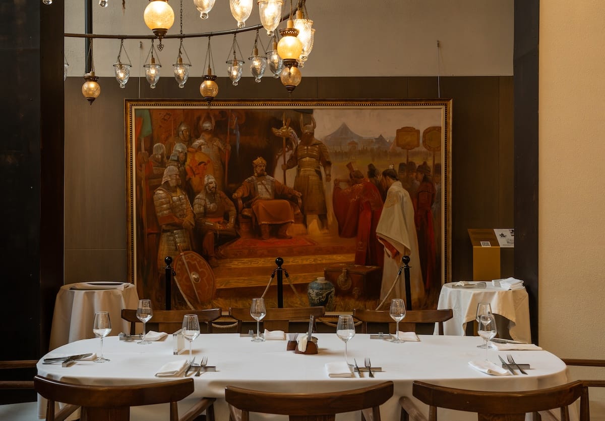 the interior of a restaurant with a beautiful lamp and painting in the background
best restaurants in almaty, kazakhstan