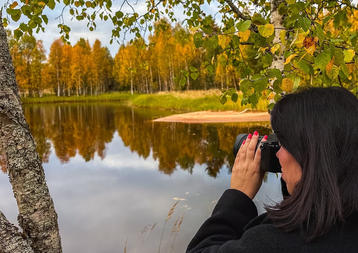 a woman photographing a resort in autumn in finland