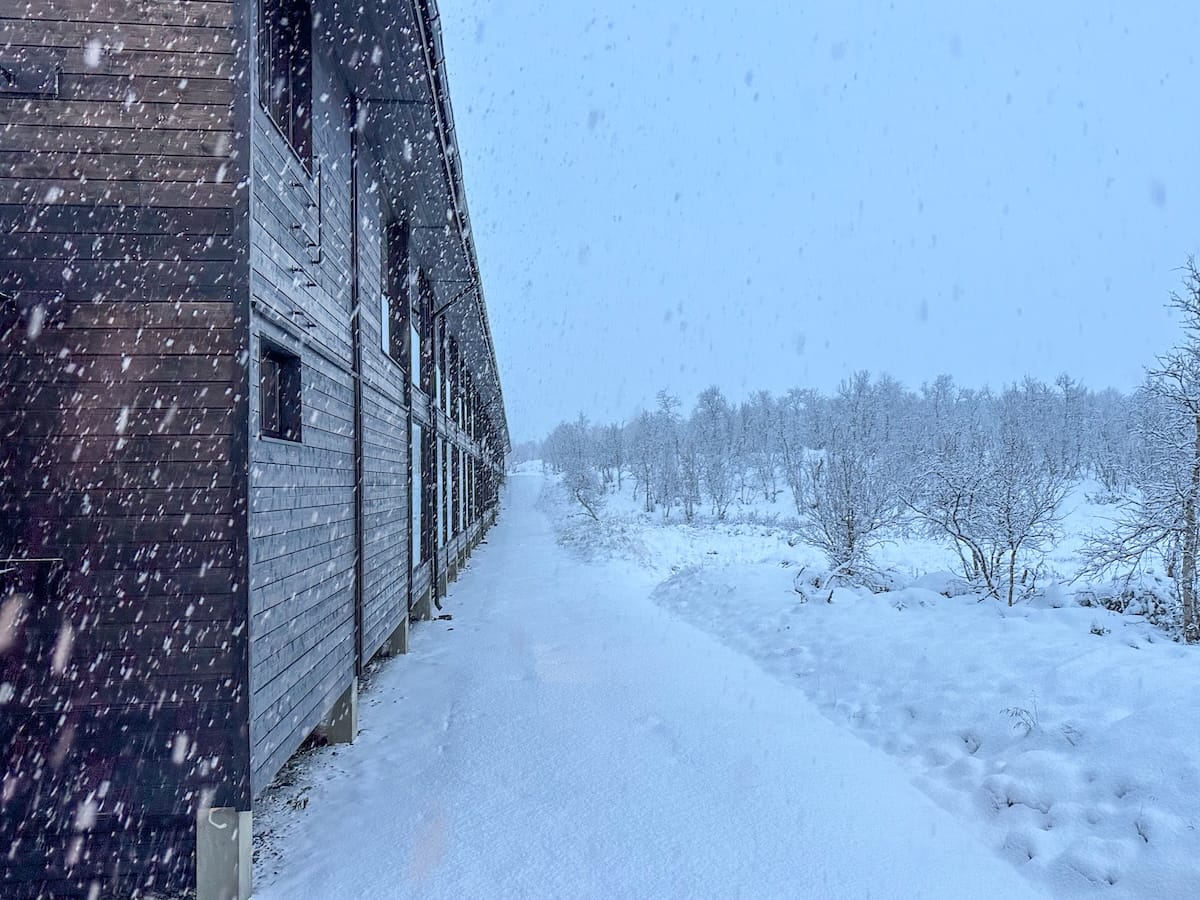 Snow in Kilpisjärvi in November | the outside of a hotel with snow on the ground