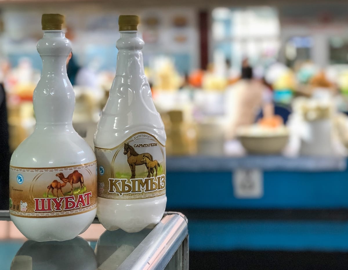 a picture of shubat (camel's milk) and kymyz (fermented mare's milk) at a bazaar in almaty