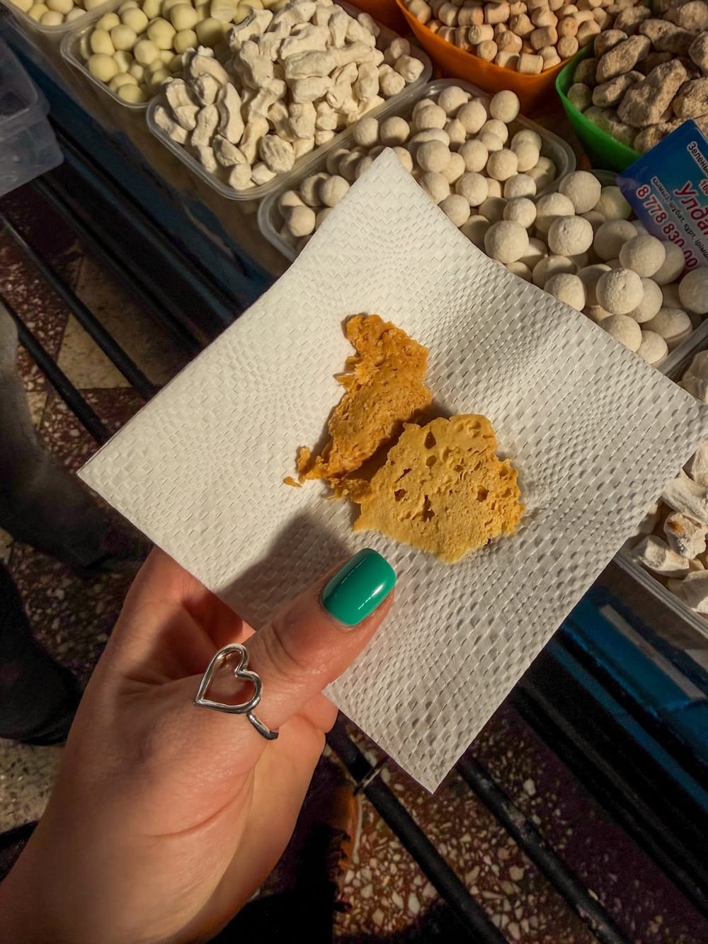a woman's hand with a sweet treat in it in a bazaar