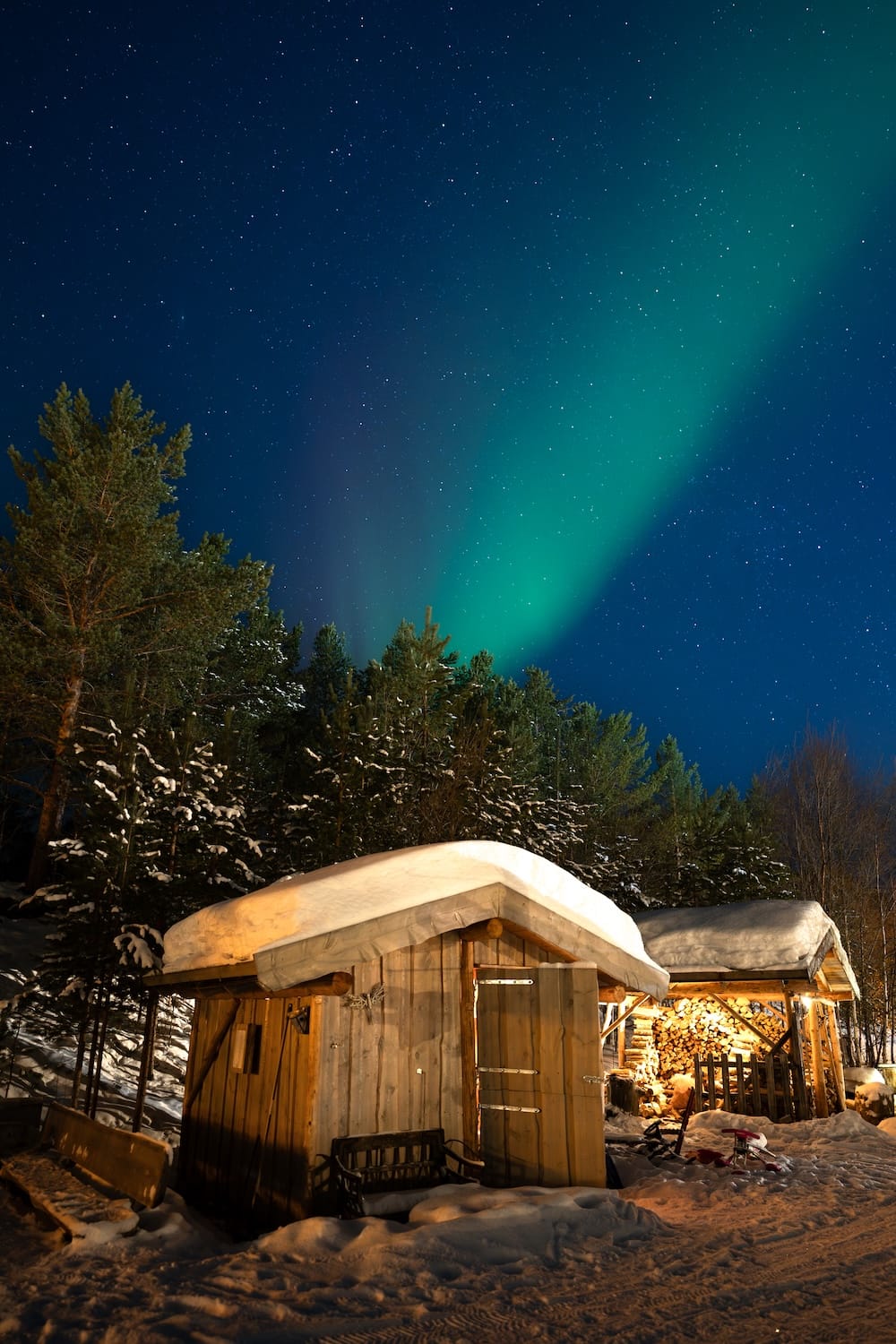 the northern lights in alta norway over a wooden cabin