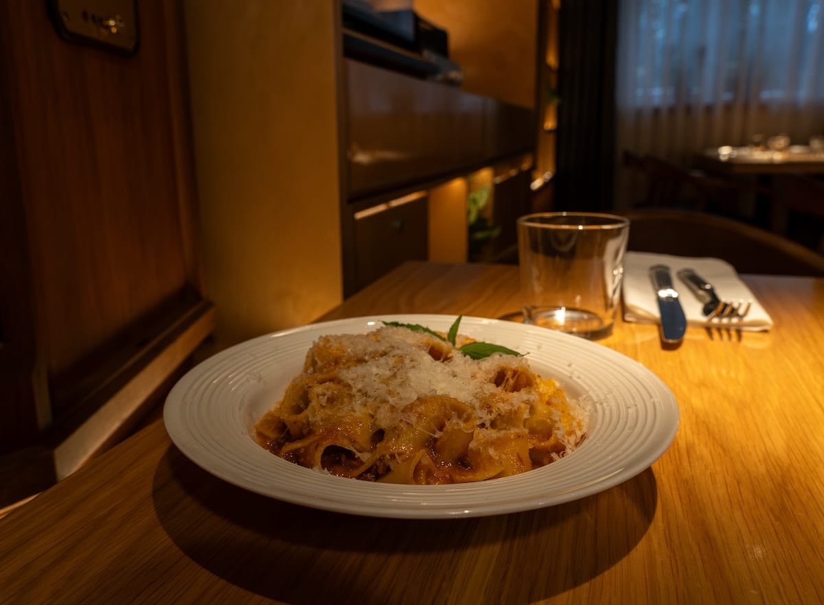 a bowl of pasta on a table with cheese on top
best restaurants in almaty, kazakhstan