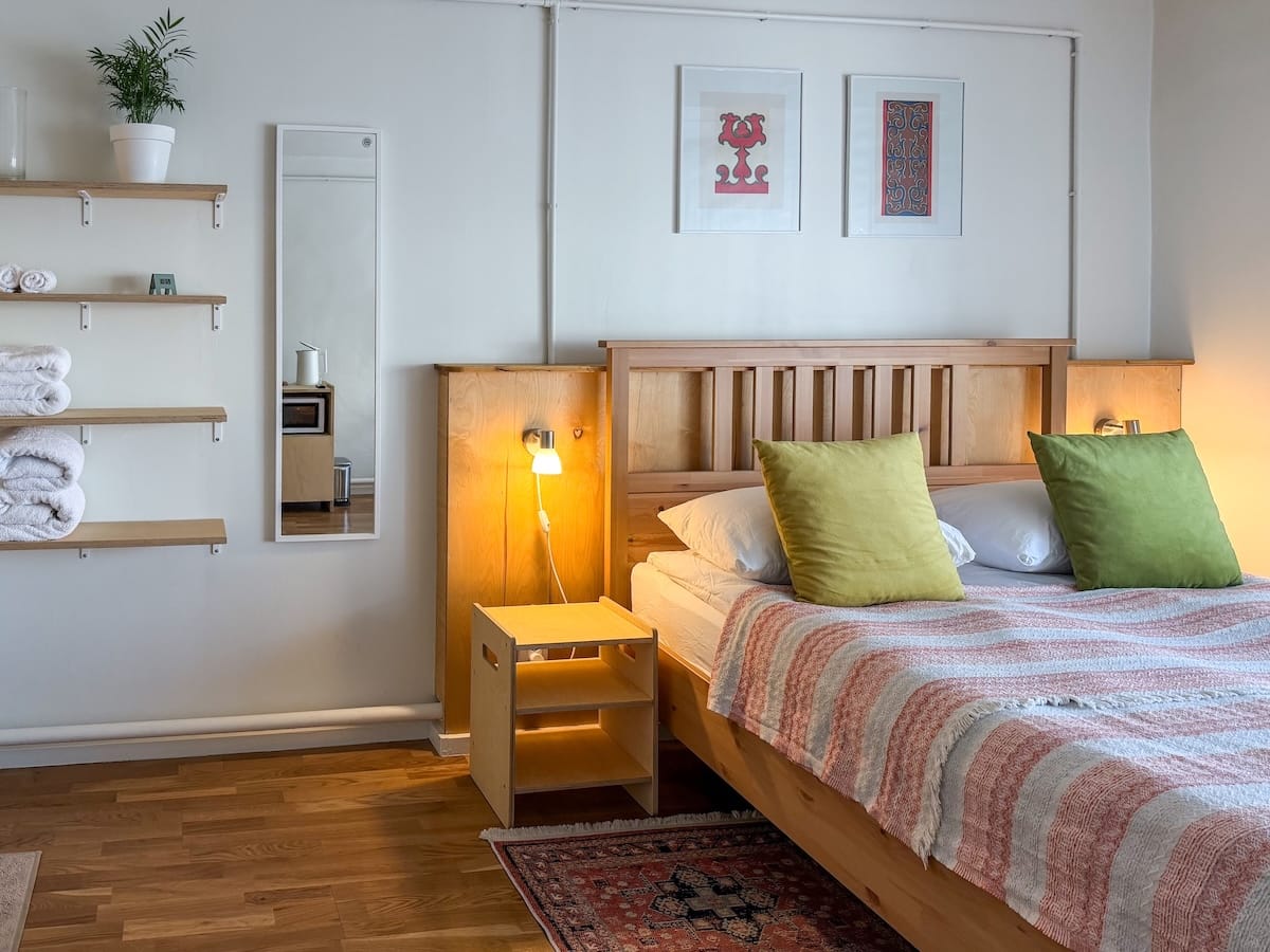 a clean hotel room with a bed and shelves