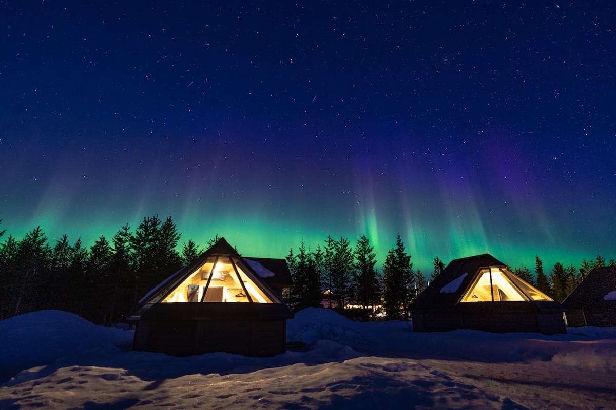 a photo of two glass igloos under the northern lights in finland