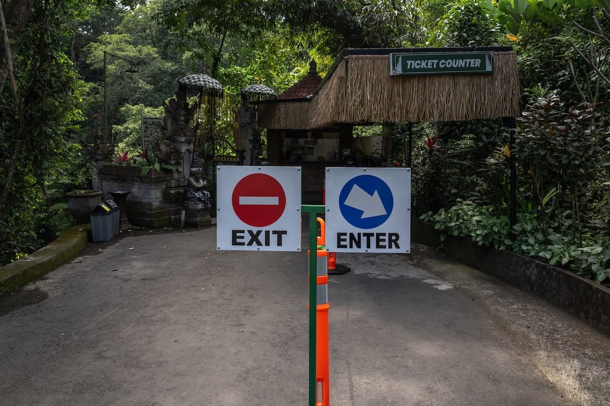 Two signs that say 'Enter' and 'Exit' so you can get in line for tickets at Kanto Lampo Waterfall