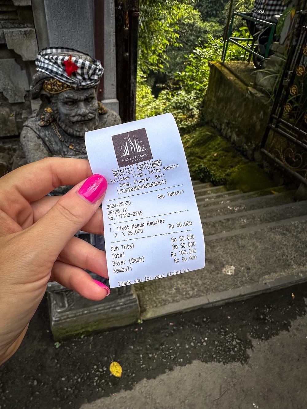 this is a photo of a piece of paper that is a ticket for Kanto Lampo Waterfall in Bali - it is 50,000 IDR for two people