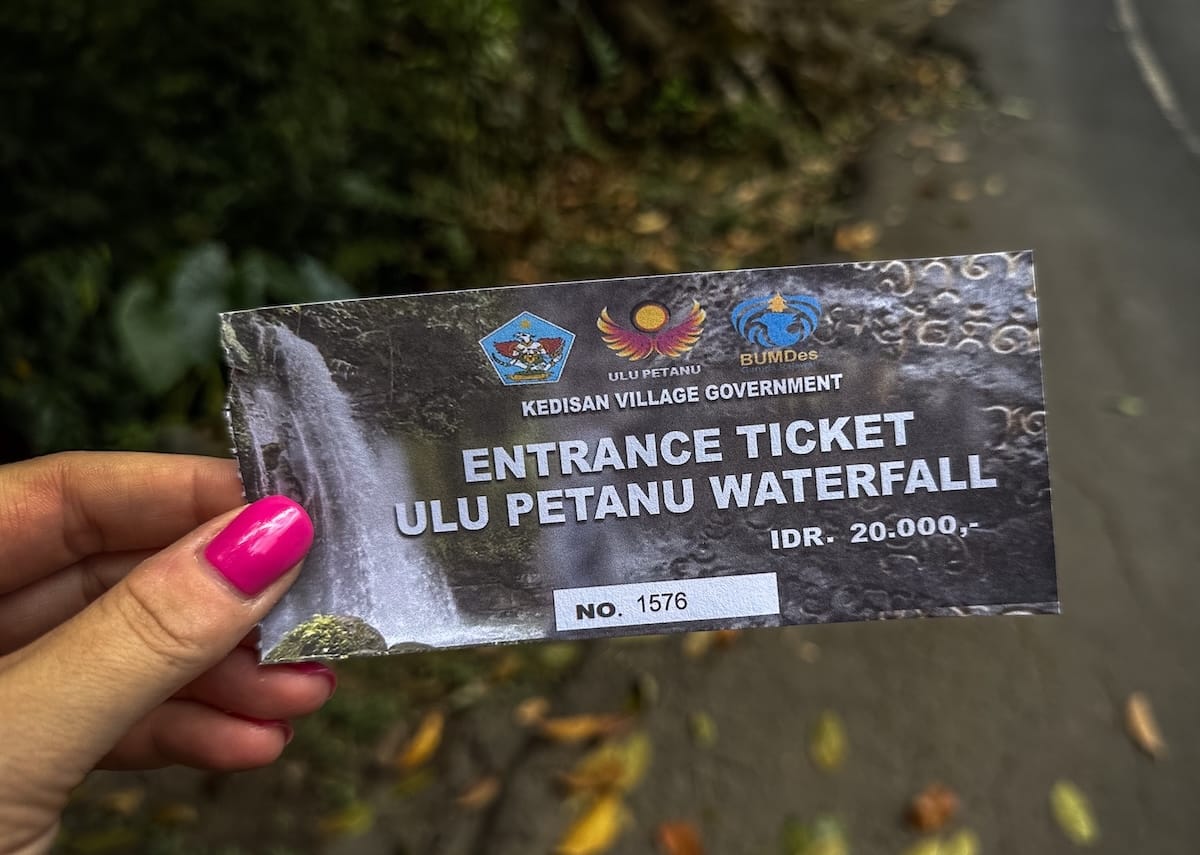 A photo of me holding my ticket to Ulu Petanu waterfall - this says it is 20,000 IDR