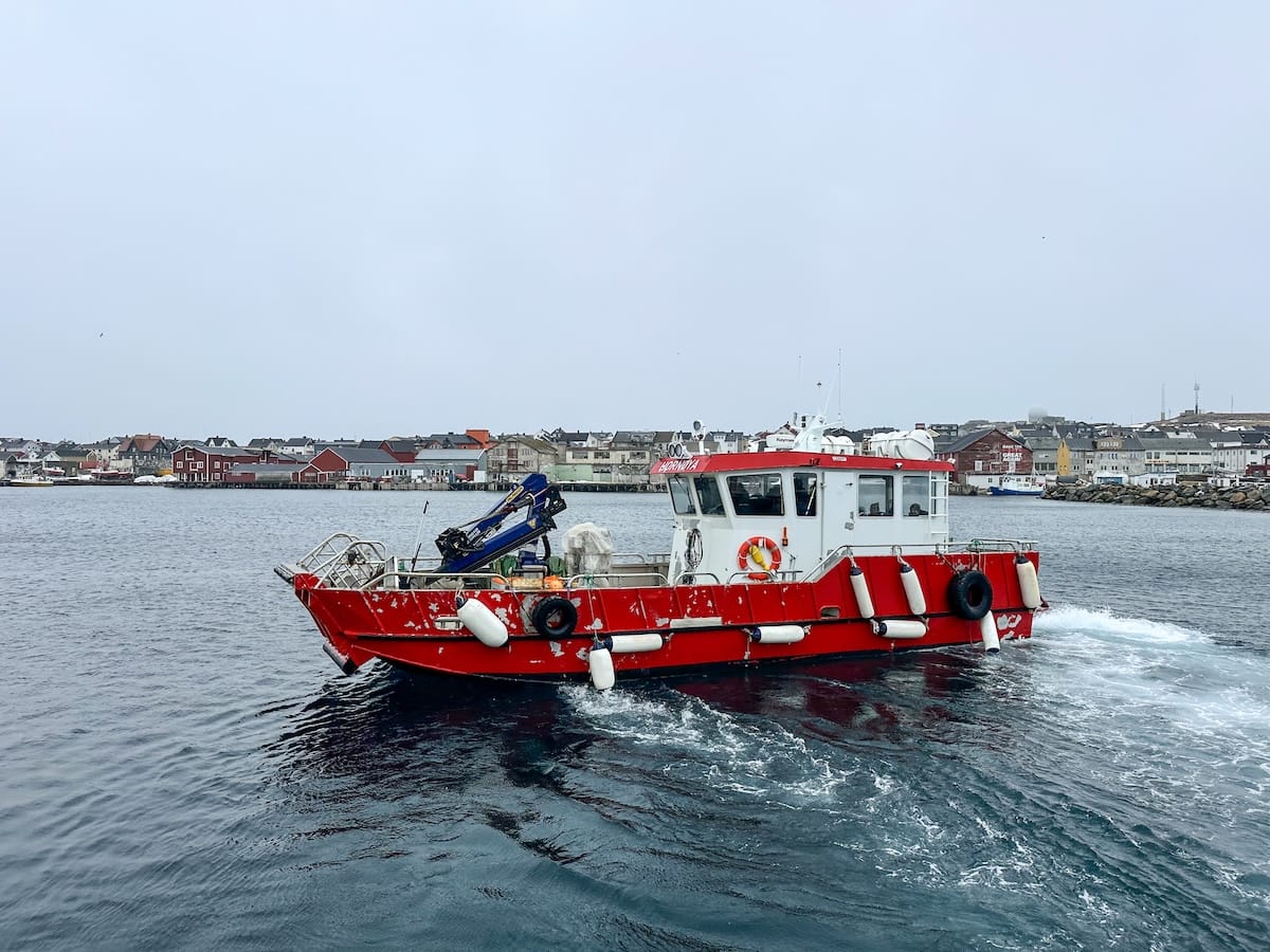 A red and white boat in the water in Vardø, Norway