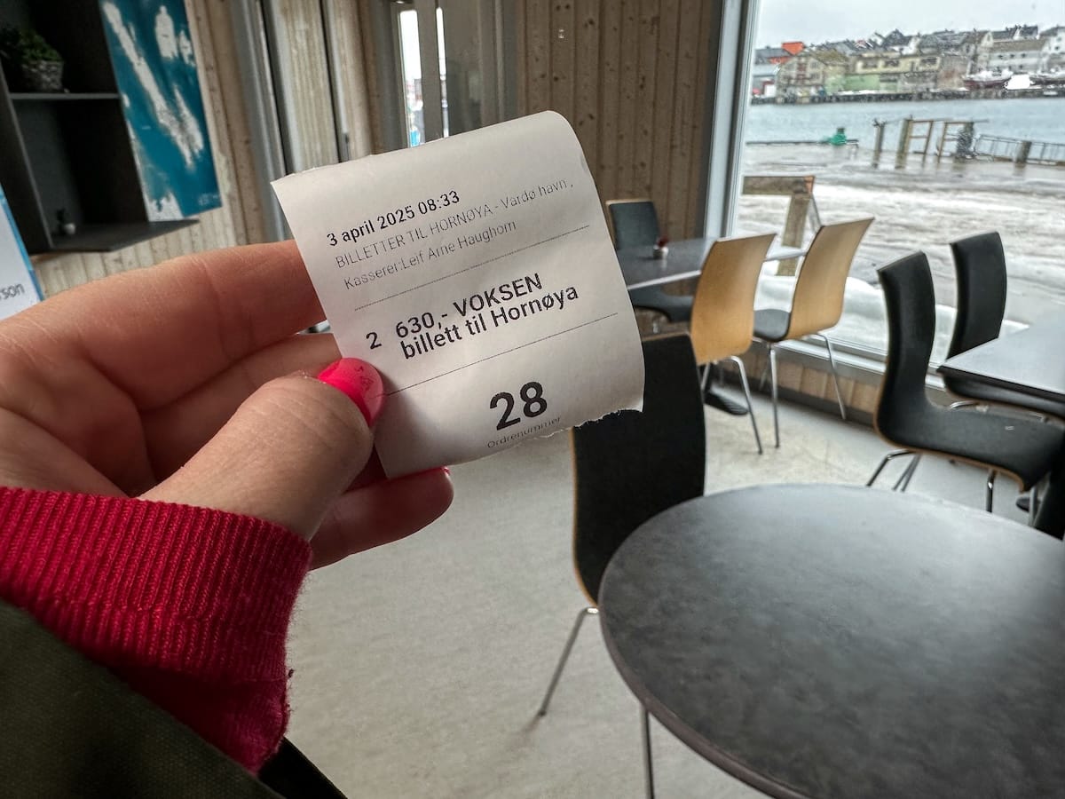 A woman holding a piece of paper that is a ticket for the boat ride