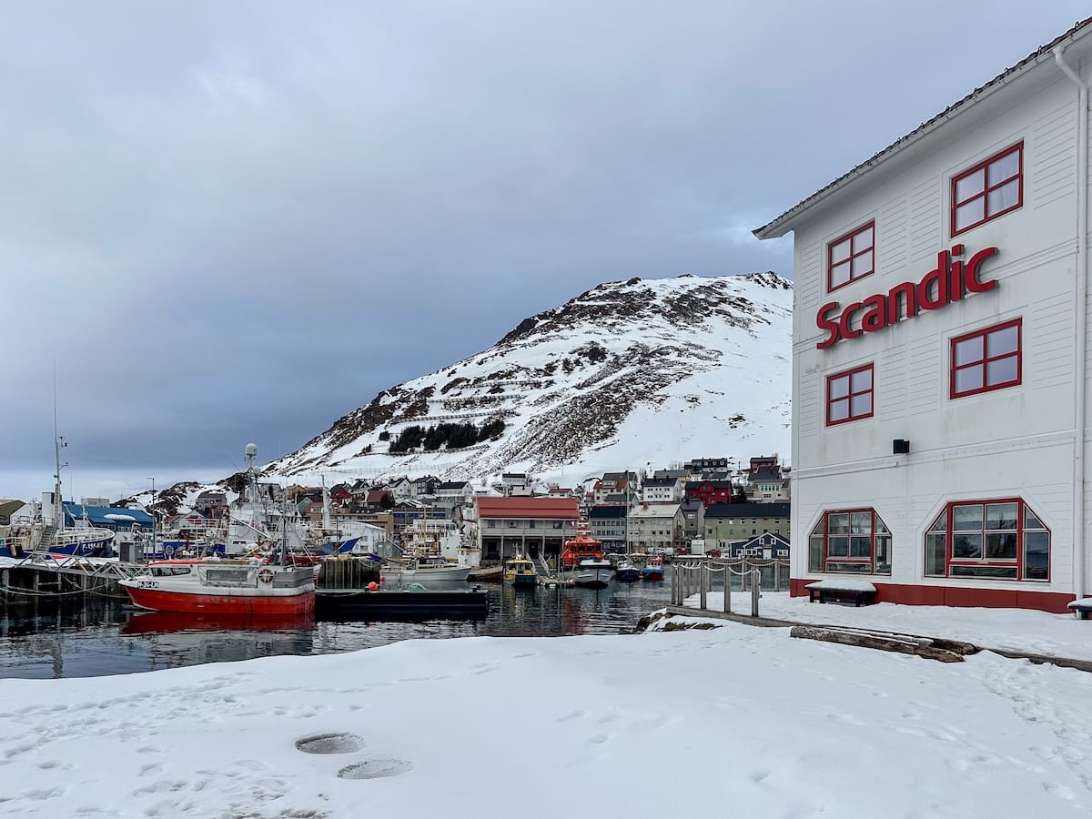 Scandic Bryggen Review - a stay on the harbor in Honningsvåg
This photo is a picture of the hotel alongside the harbor with snow on the ground and boats in the water.