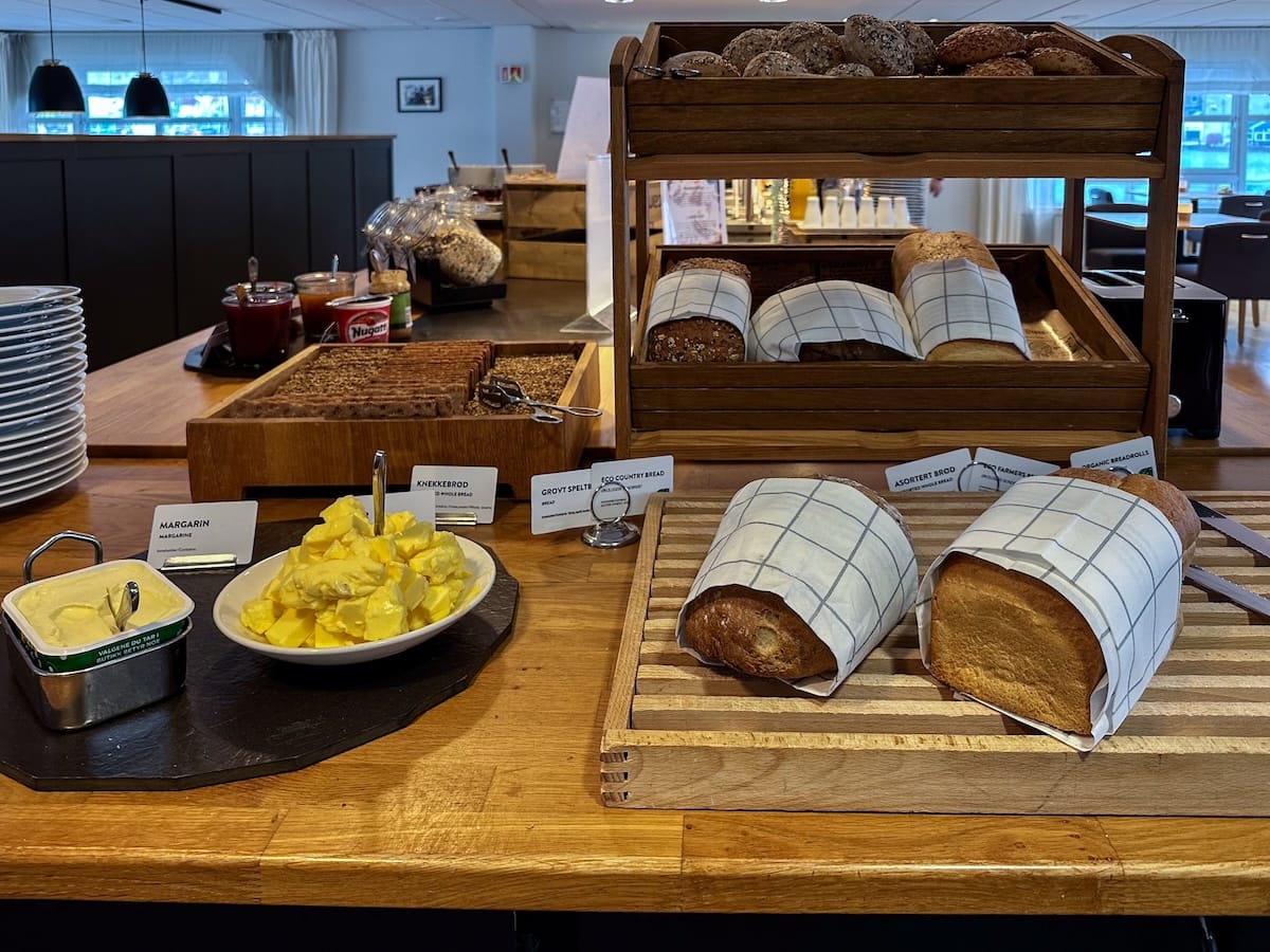 Bread at the breakfast at Scandic Bryggen in Honningsvåg, Norway. There are two different types of bread here, both wrapped in napkins for cutting them. There is butter beside it.