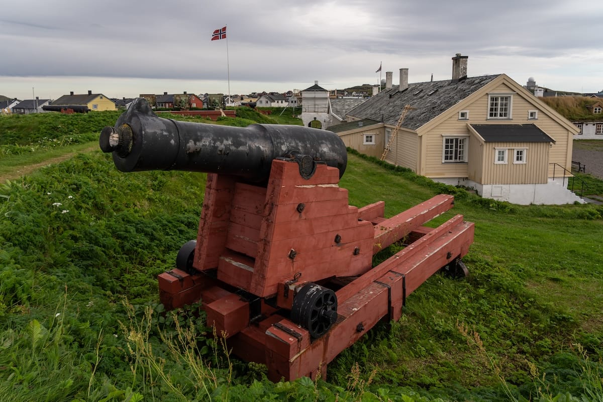 A red cannon on top of a small hill at a fortress in Vardø, Norway