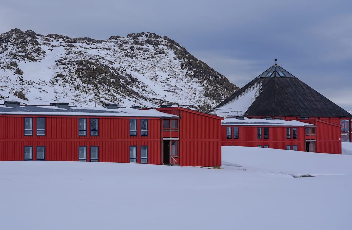 Scandic Nordkapp hotel on the way to North Cape
This is a photo of a red wooden hotel surrounding by snowy mountains and snow covered ground.
