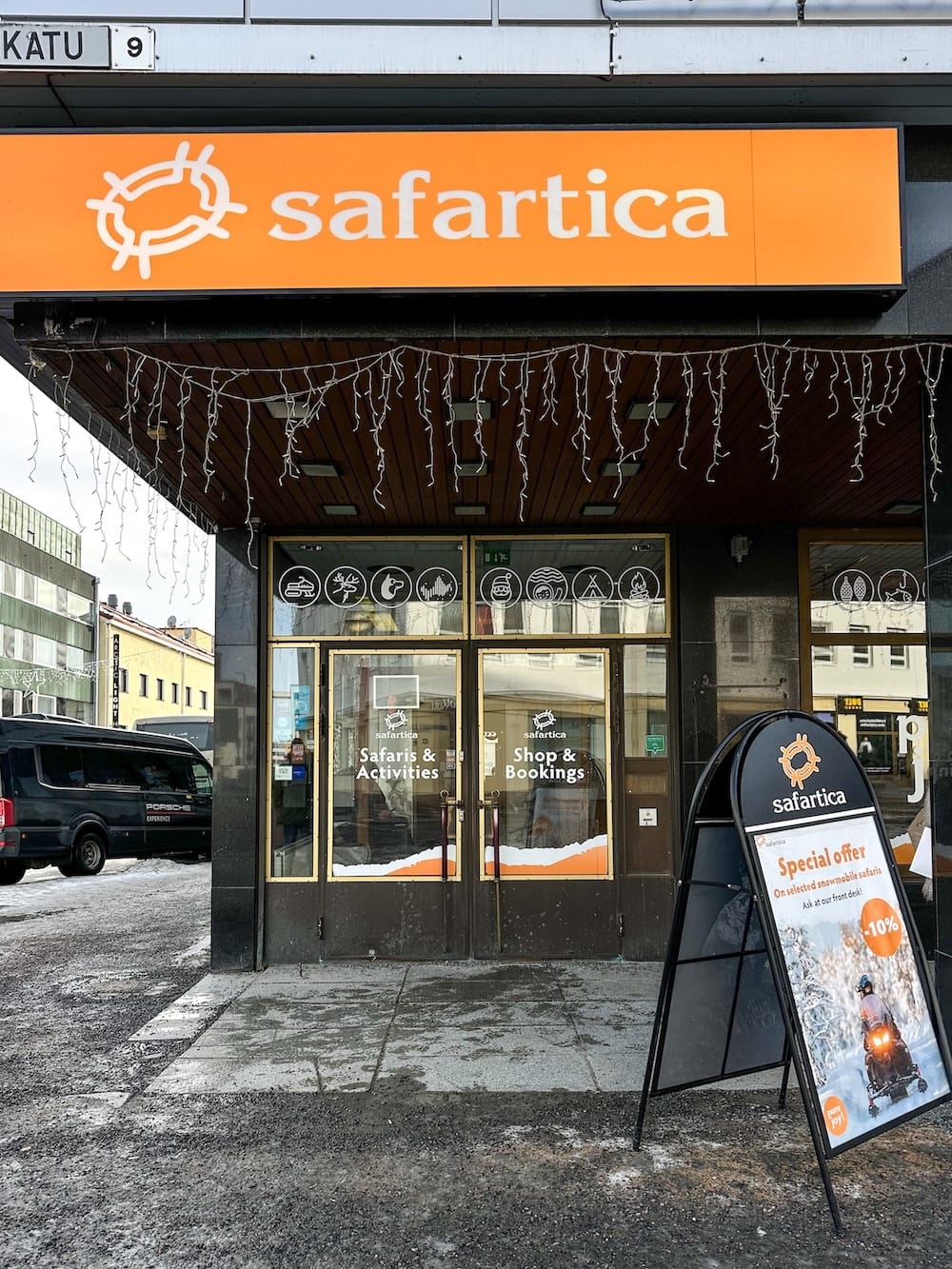 Snowmobiling in Rovaniemi, Finland: Best tours, tips, and what to expect.
Photo: this is a picture of the Safartica office in Rovaniemi, Finland. Their branding is orange and white and they have a sign outside their door.