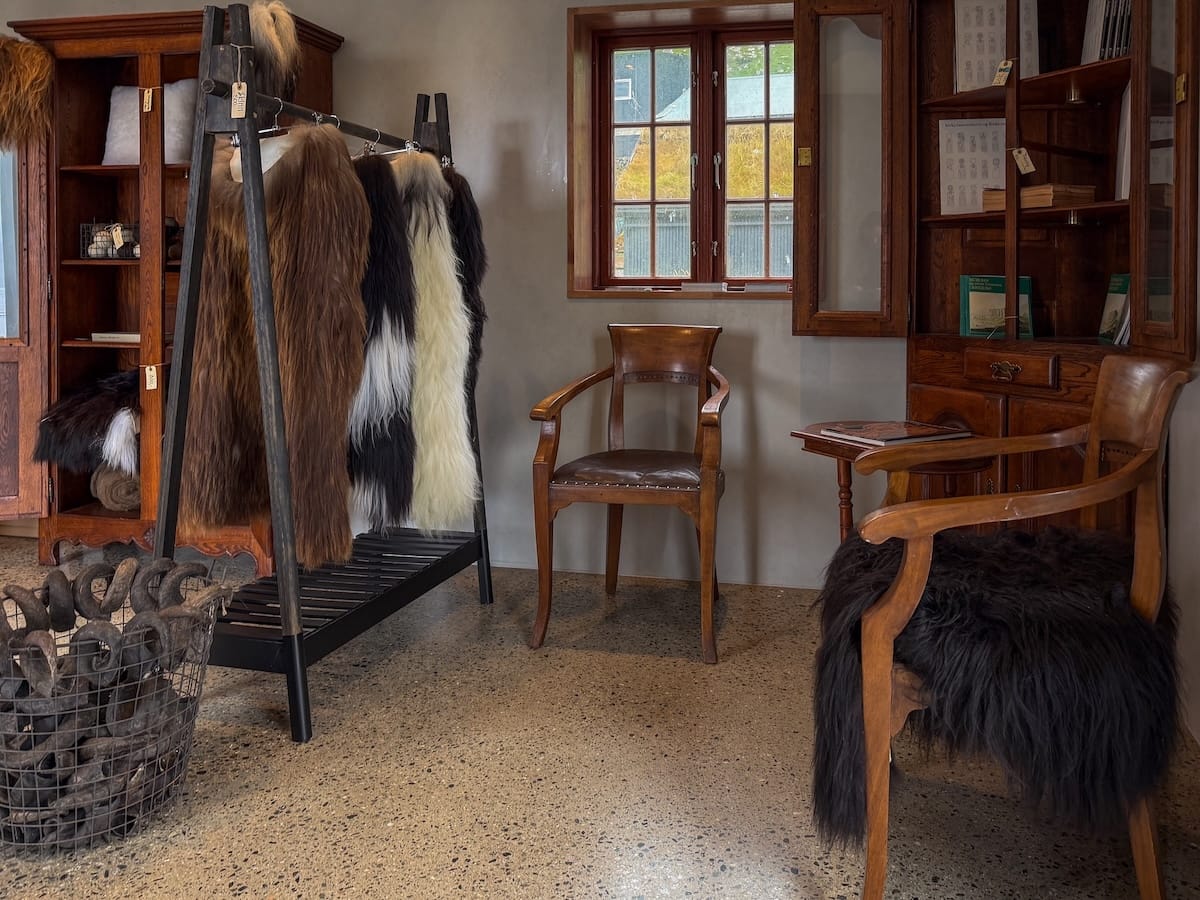 a gift shop with wool goods, a chair, and a window