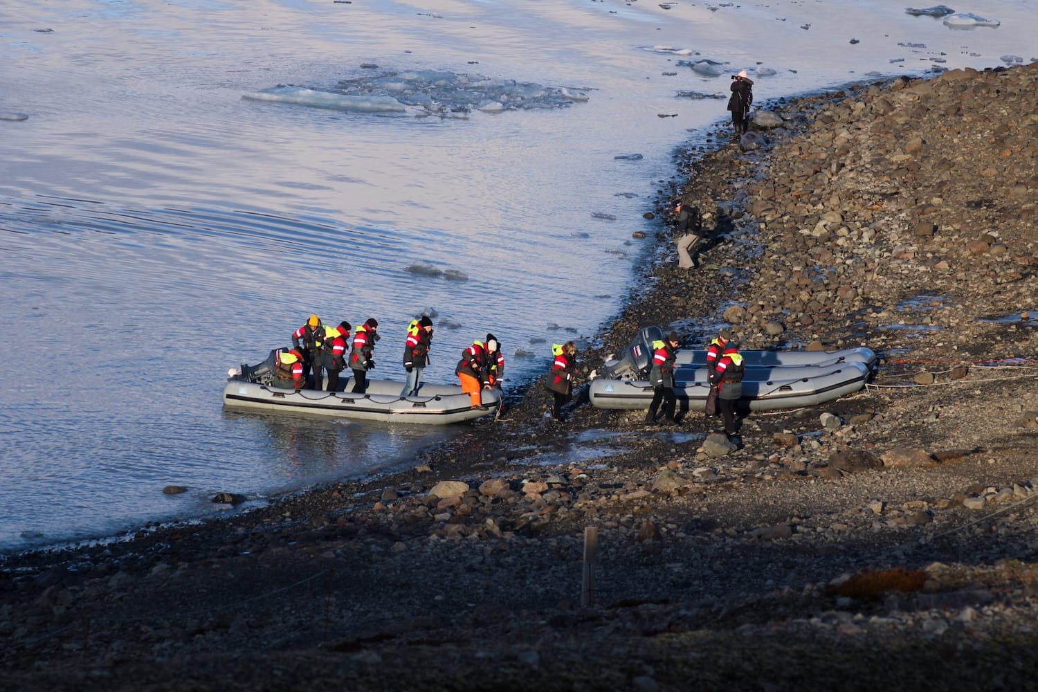 People getting on a boat to take a tour of the lagoon in Iceland. The boat is a Zodiac raft