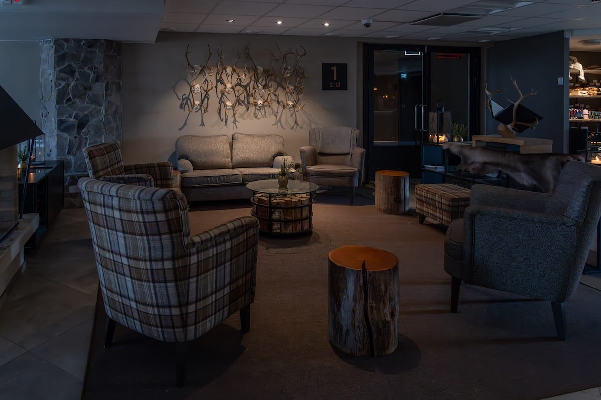 The lobby at Lapland Hotels Ounasvaara - a few chairs and couches with reindeer antlers on the wall