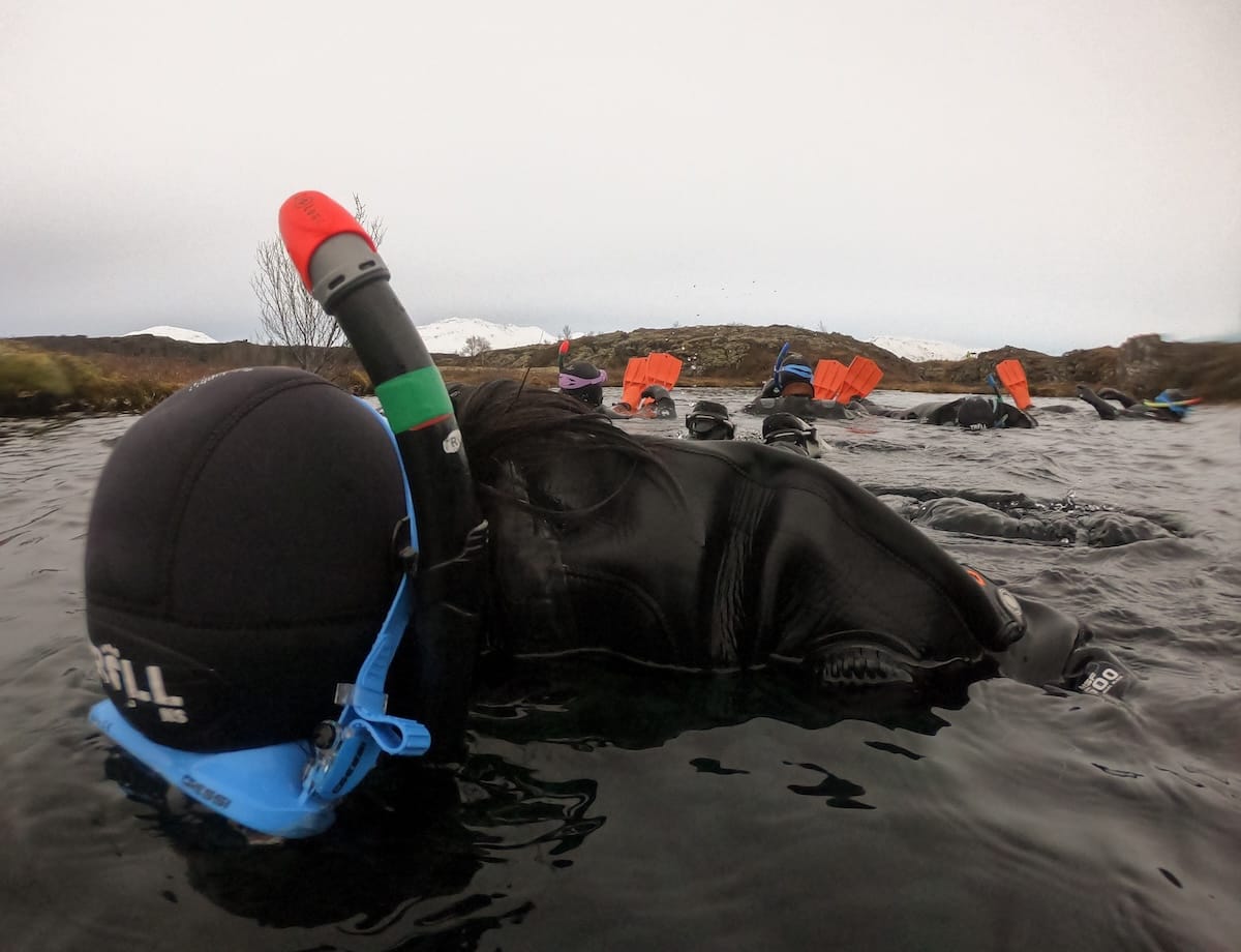 This is a person floating in a drysuit in the Silfra fissure in Iceland