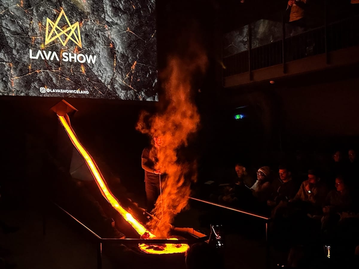 Photo is of a performance called the Lava Show - this photo is showing lava coming out from a place in the wall with a person helping discuss about its features and properties.