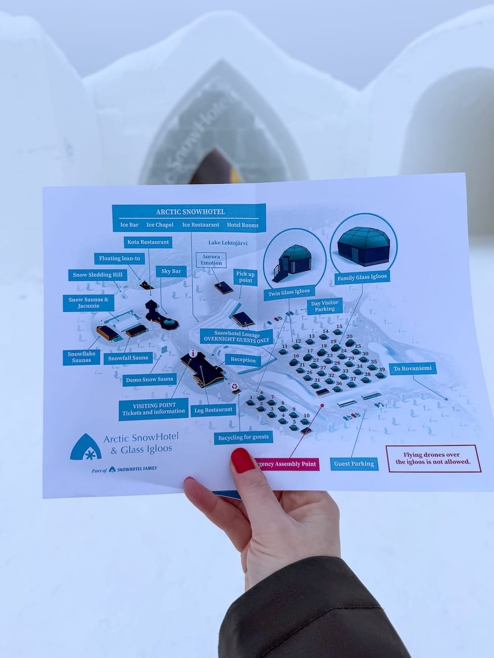 Visiting the Arctic SnowHotel in Rovaniemi
______

a woman holding a map of an ice hotel complex