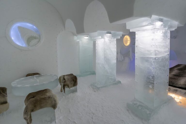 Visiting the Arctic SnowHotel in Rovaniemi ______ a room made of ice with a small table and chairs area