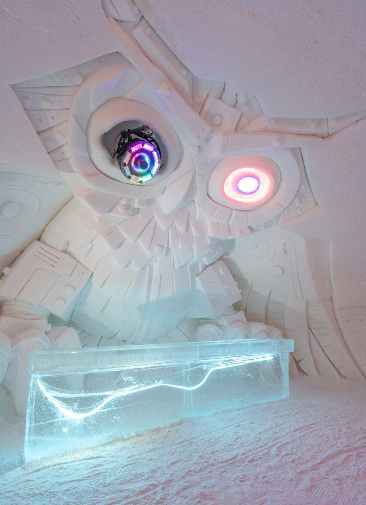 inside an ice hotel; a sculpture of an owl made from snow and ice