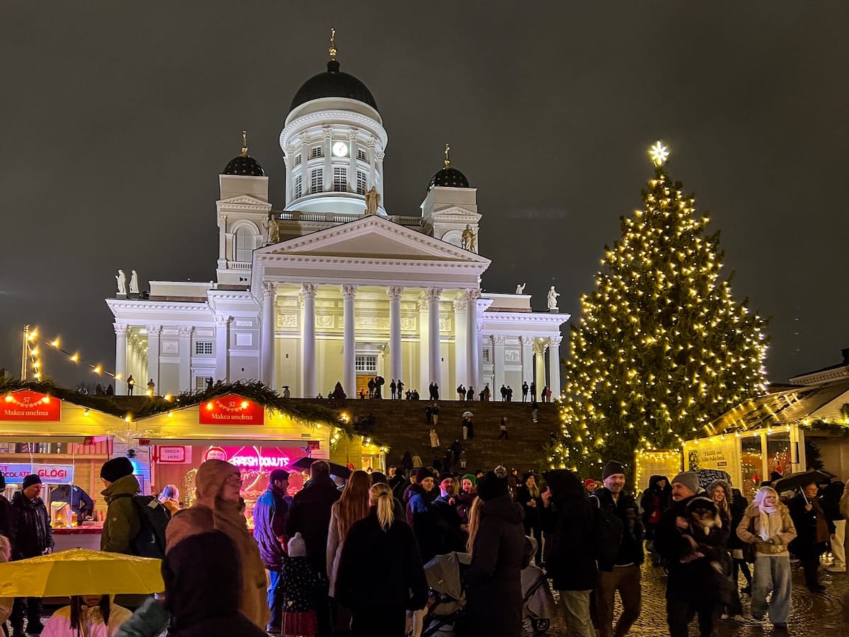 a Christmas market in Helsinki in front of a large white cathedral