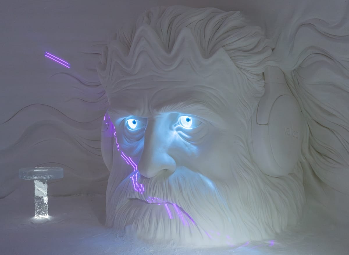 an ice carving of a man with some neon lights in an ice hotel