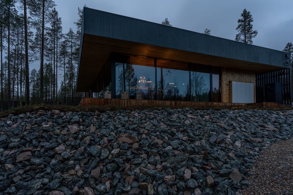 A large building with reflective glass in a Finnish forest