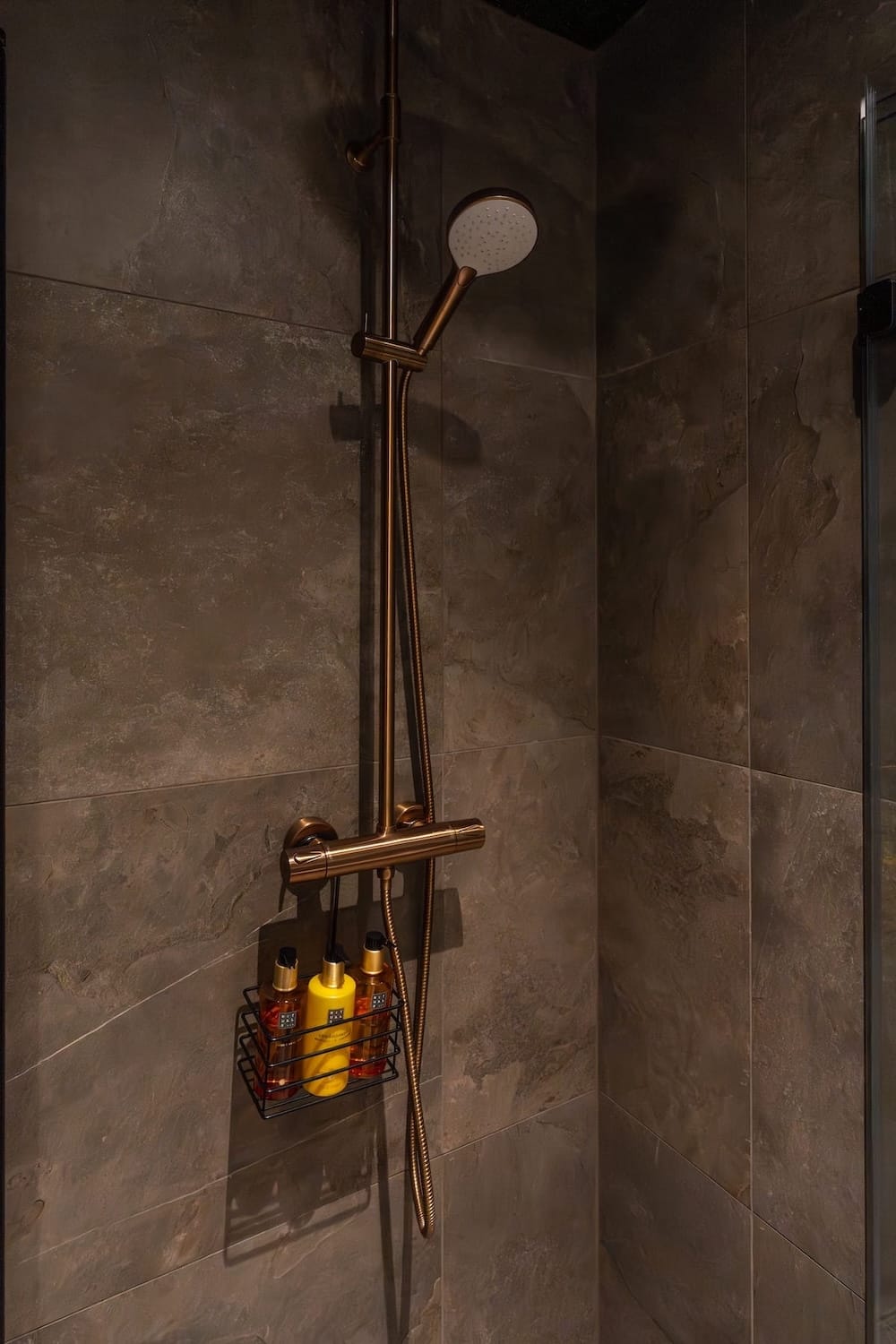 a dark bathroom with Rituals bath products