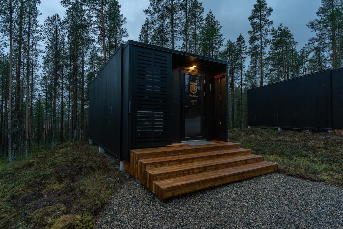 a black cabin in a finnish forest