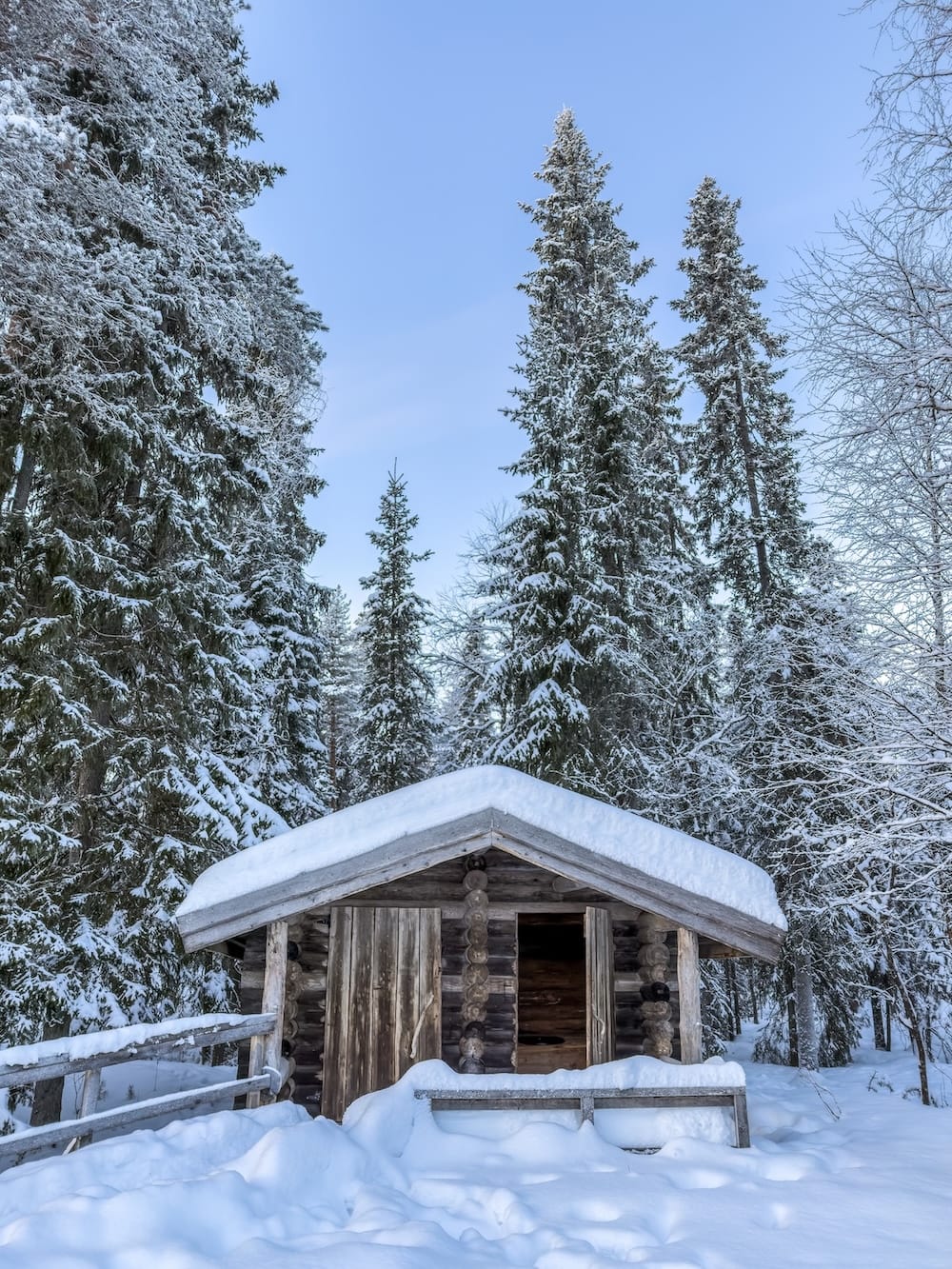 a snowy finnish forest with a wooden hut