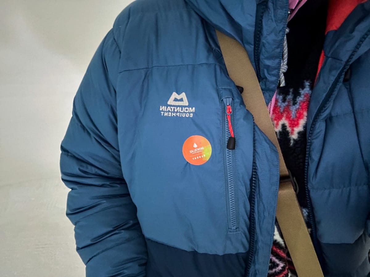 How to visit Lapland Hotels SnowVillage from Levi and Ylläs
Photo: A woman in a blue jacket with an orange sticker for entrance to the ice hotel.