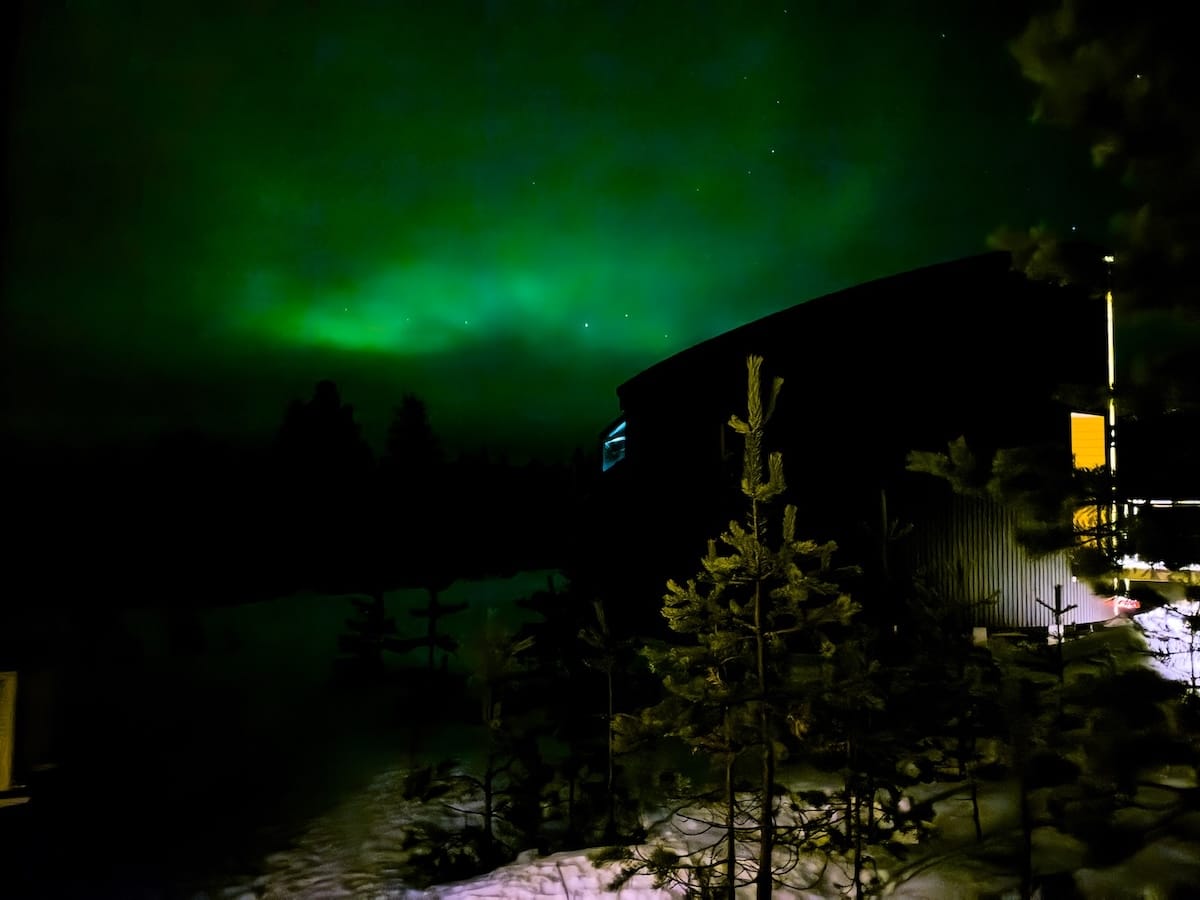 Livo Arctic Resort
_____
A green aurora in the background of a dark cabin in Finland