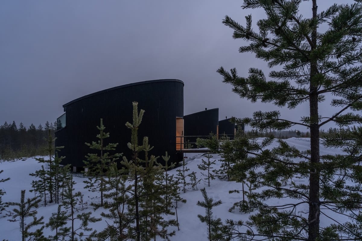 Livo Arctic Resort
_____
a modern resort in Lapland with pine trees in front of the dark, circular cabins