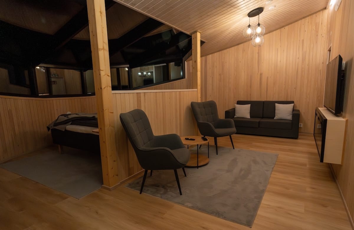 Livo Arctic Resort
_____
Inside a wooden cabin with a sofabed, two chairs and table, and a bed behind it