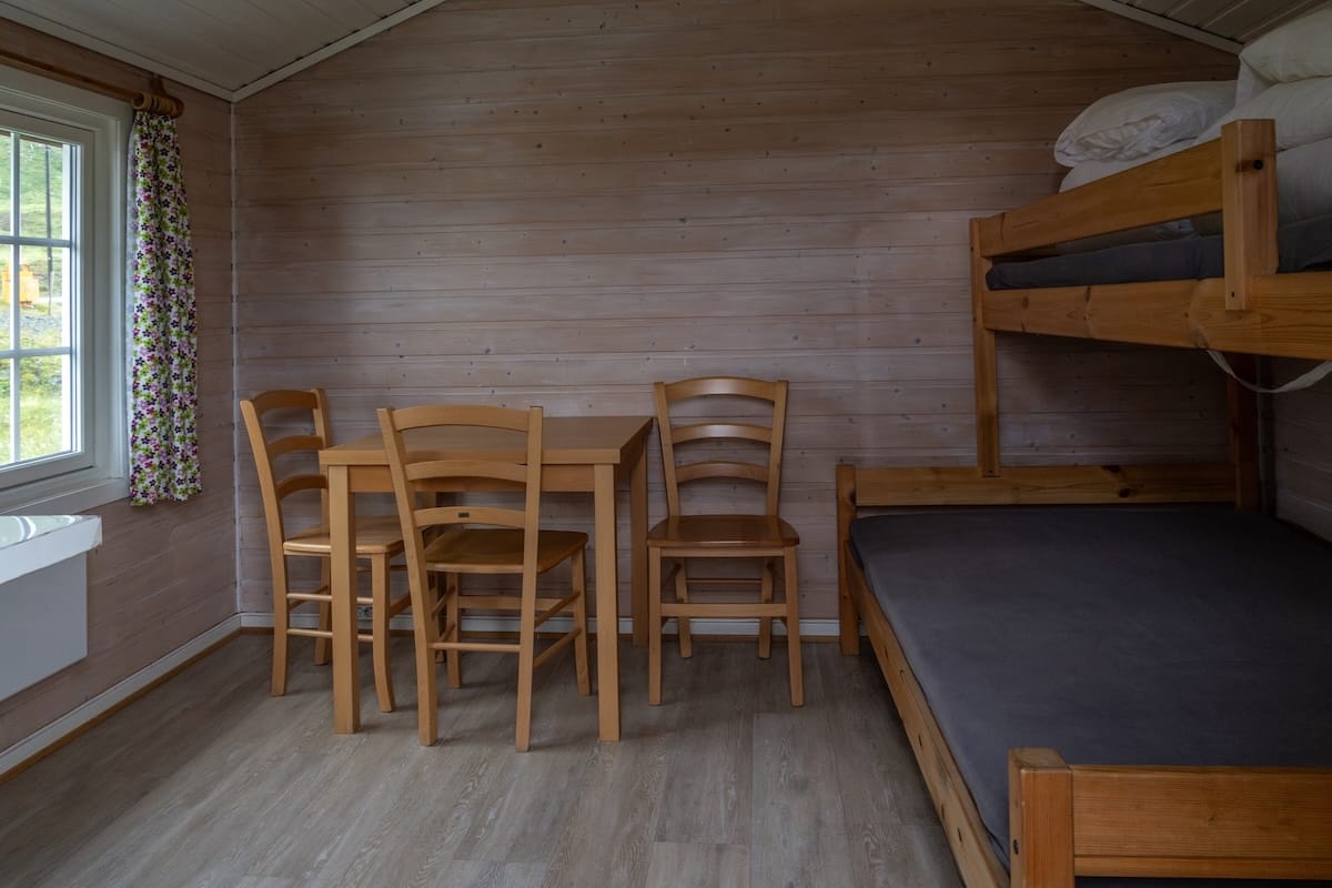 Where to Stay at the North Cape in Norway (+ Honningsvåg)
inside a cabin with a table and a bunkbed without sheets