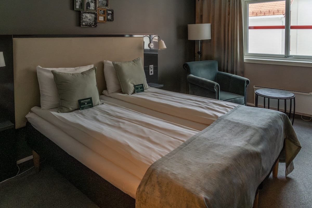 Where to Stay at the North Cape in Norway (+ Honningsvåg)
A hotel bed for two with a chair and window in the background